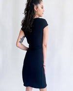 Load image into Gallery viewer, curly haired woman in black ribbed high slit dress short sleeve black dress
